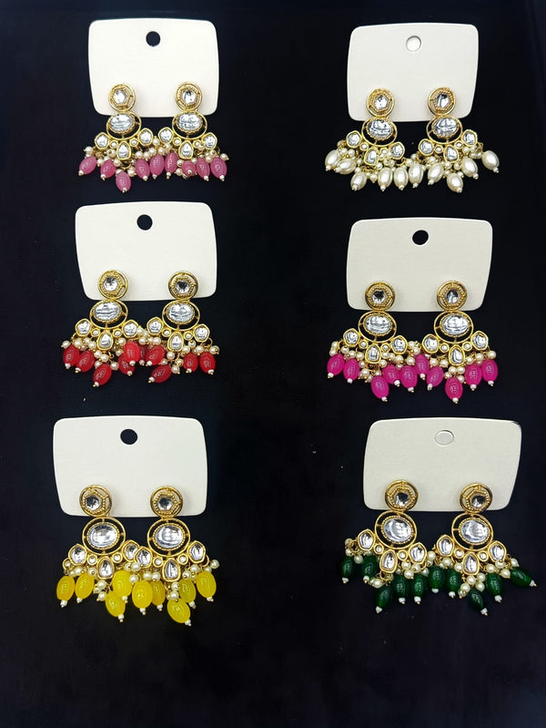 Set of colorful earrings on white cards against a dark background