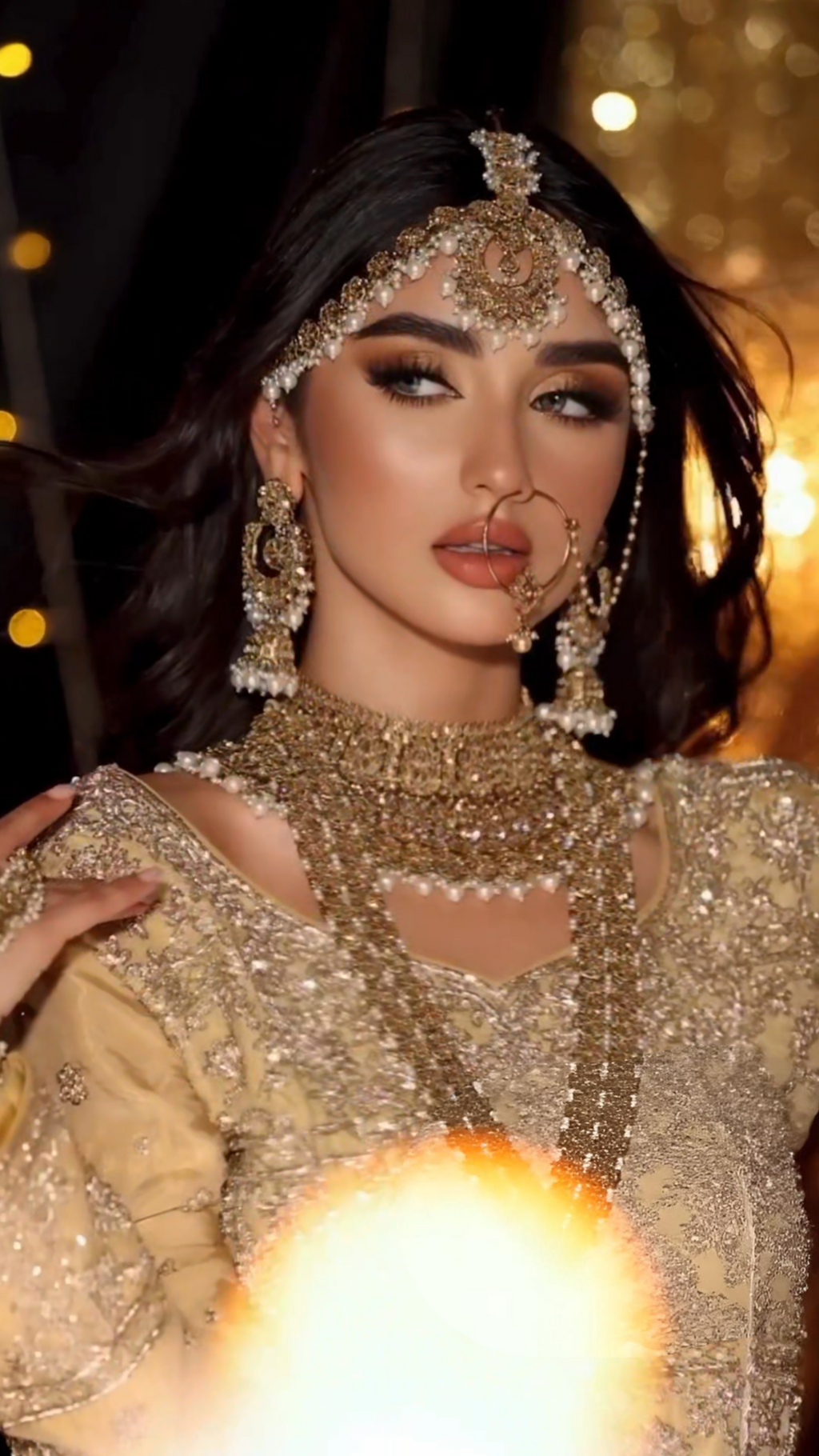 Woman in elaborate traditional attire with jewelry against a blurred background